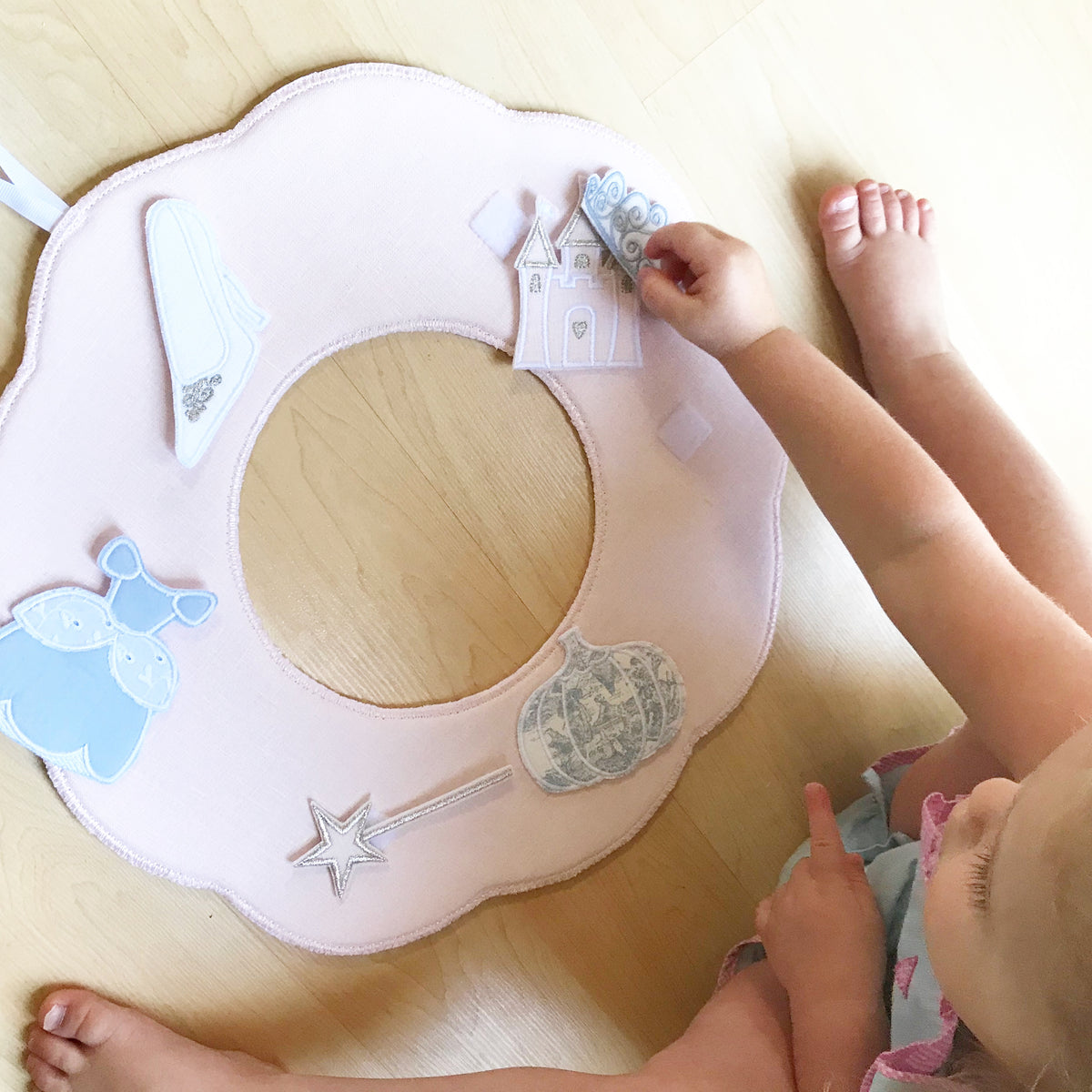 Child playing with a handmade pink scalloped Cinderella keepsake with castle, glass slipper, pumpkin and wand pieces