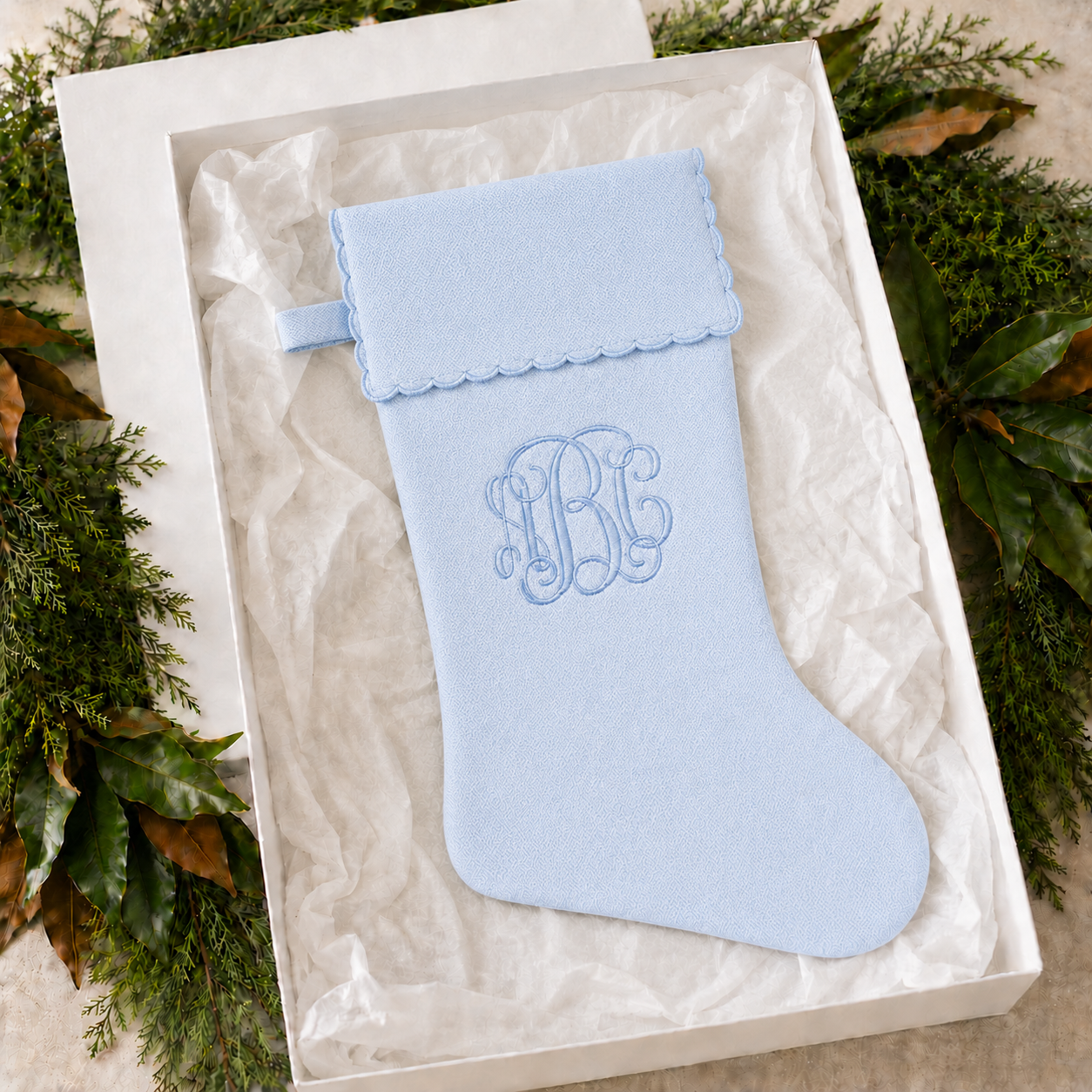 Personalized blue cotton piqué Christmas stocking with scalloped cuff in a gift box