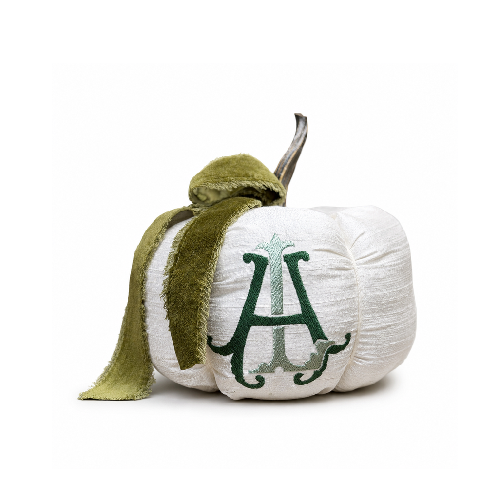 Heritage ivory silk personalized pumpkin with green velvet bow centered on a white background