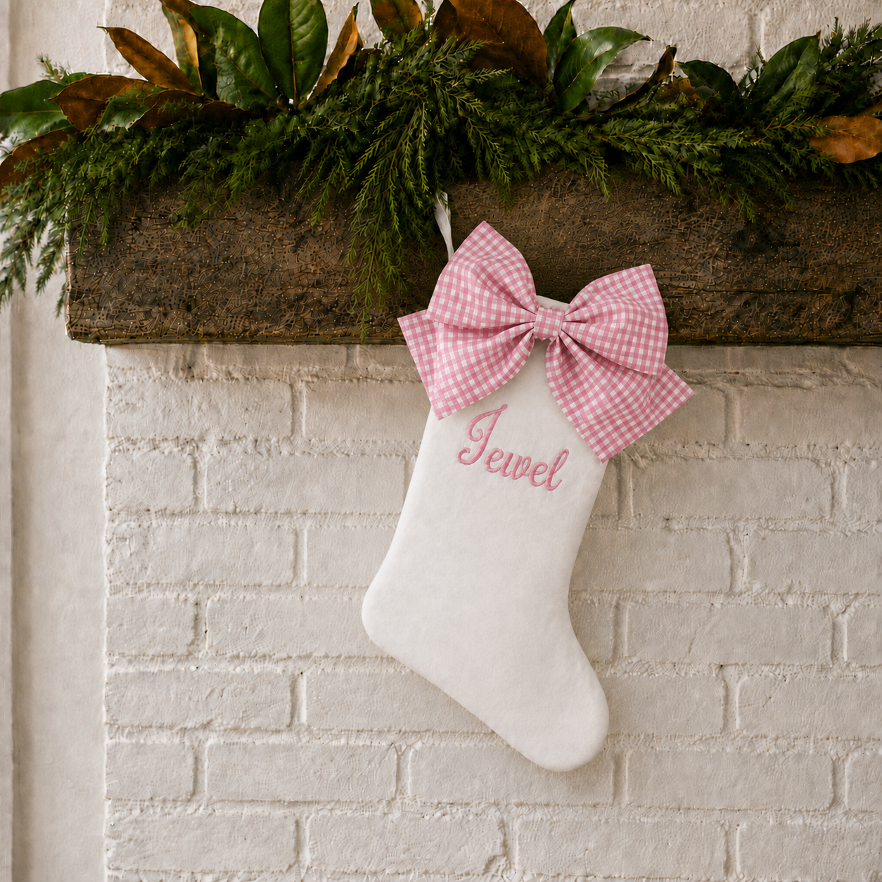 Personalized Christmas stocking with pink gingham bow styled on a holiday mantel