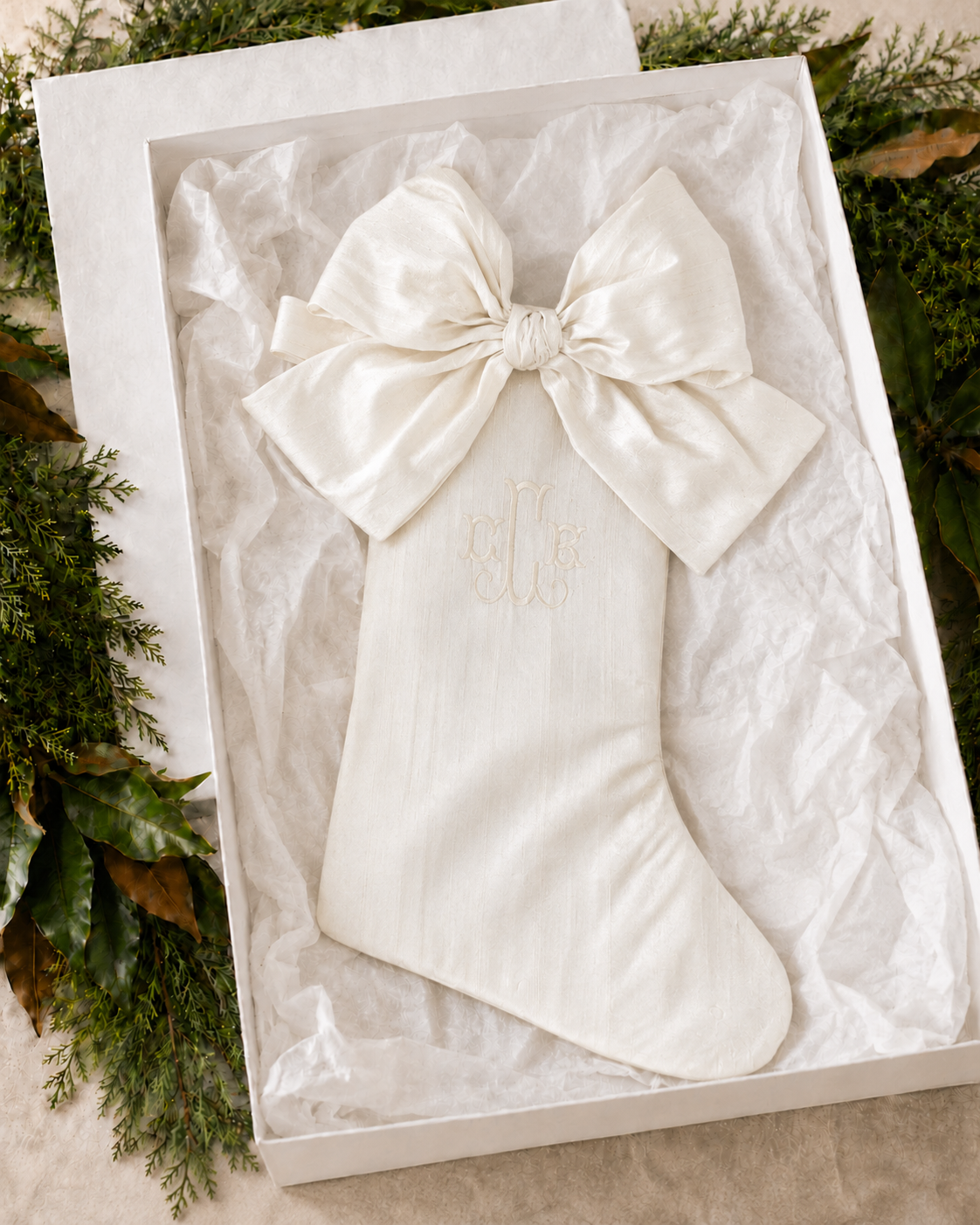 Personalized ivory silk dupioni Christmas stocking with removable bow in a white gift box